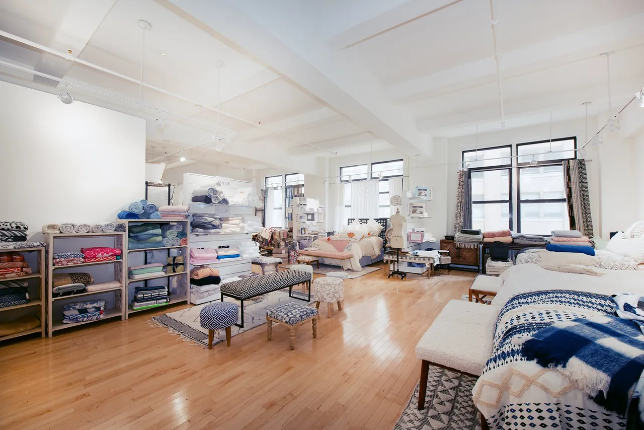 Home textiles showroom with beds, shelving and maple floors